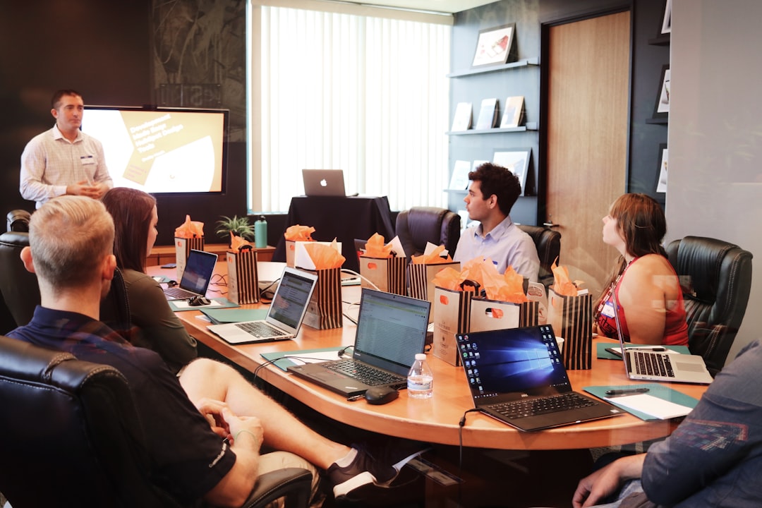 heros-img man-standing-in-front-of-people-sitting-beside-table-with-laptop-computers-gmsnxqiljp4