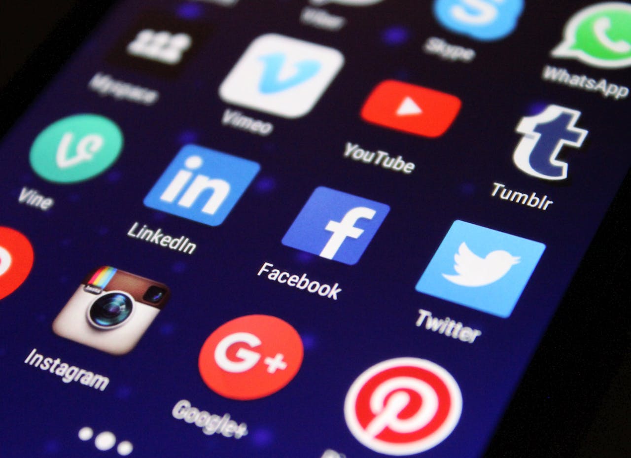 Services-02 Close-up of a smartphone screen showing various social media app icons such as Facebook and Twitter.