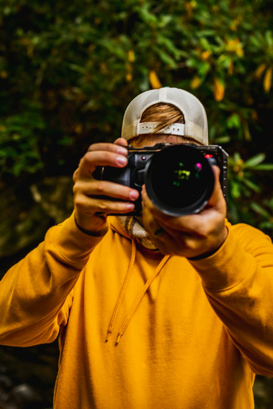 creative Man holding a camera with both hands recording with the back magic pocket cinema camera 6K.